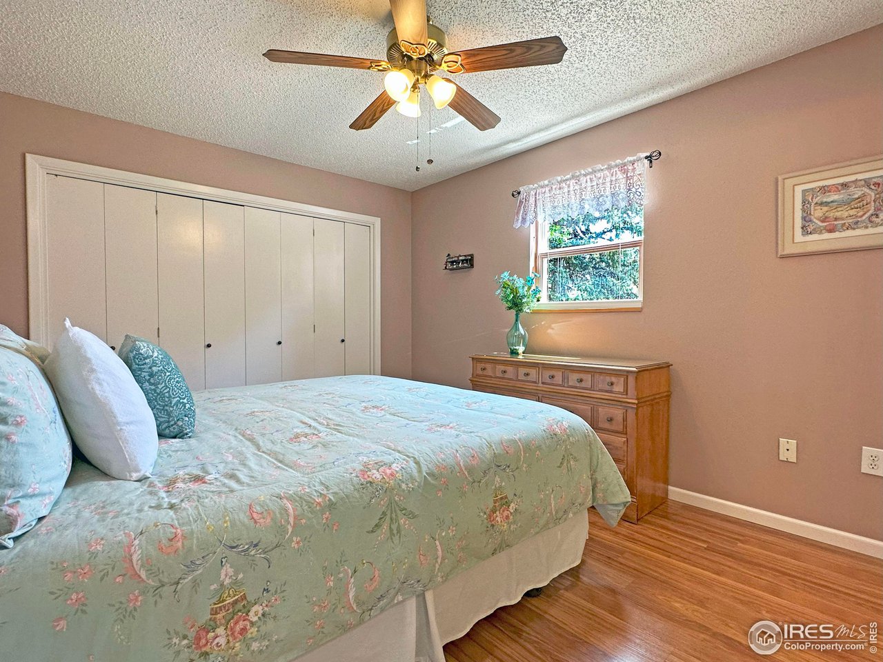 807 Locust Street Windsor, CO 80550 - Photo 15 of 40 a bedroom with a bed and a chandelier