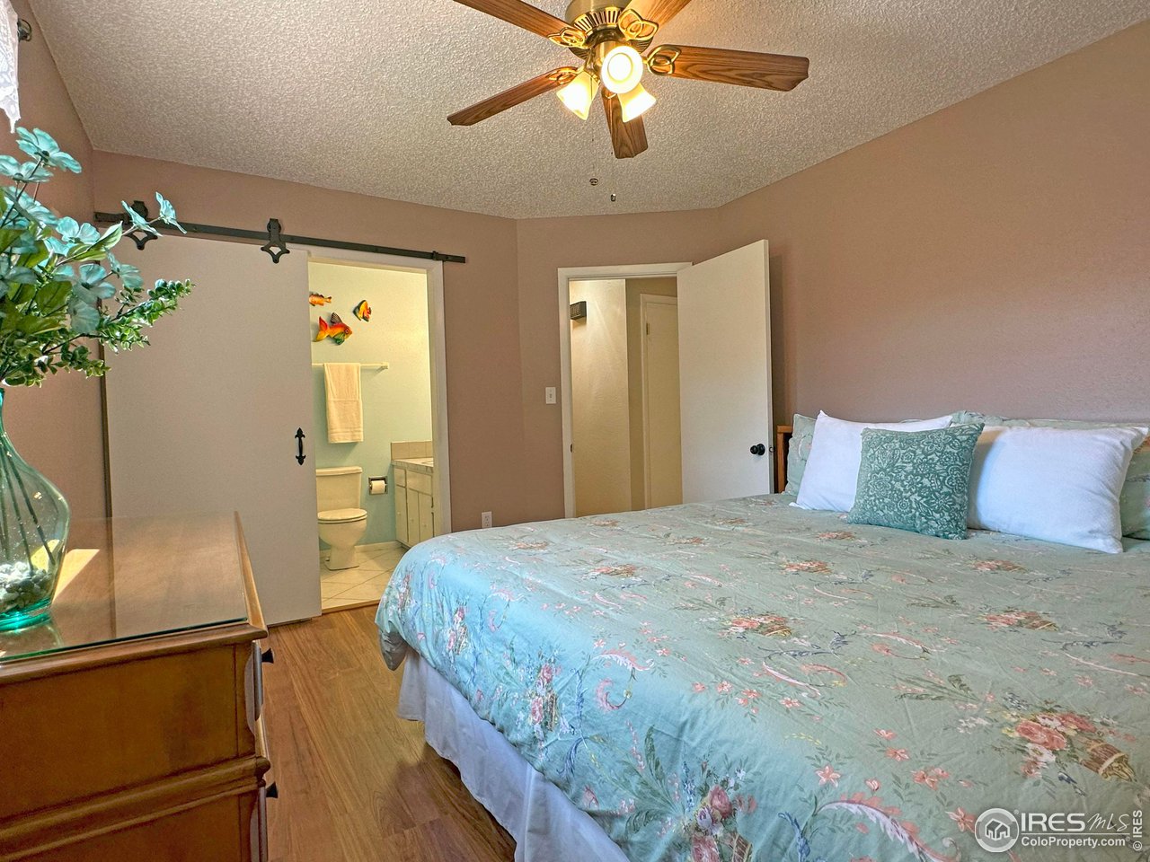 807 Locust Street Windsor, CO 80550 - Photo 16 of 40 a bedroom with a bed and a chandelier