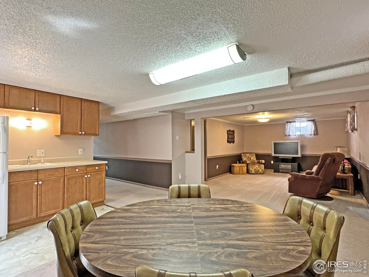 807 Locust Street Windsor, CO 80550 - Photo 23 of 40 a large white kitchen with wooden floor a sink and chairs