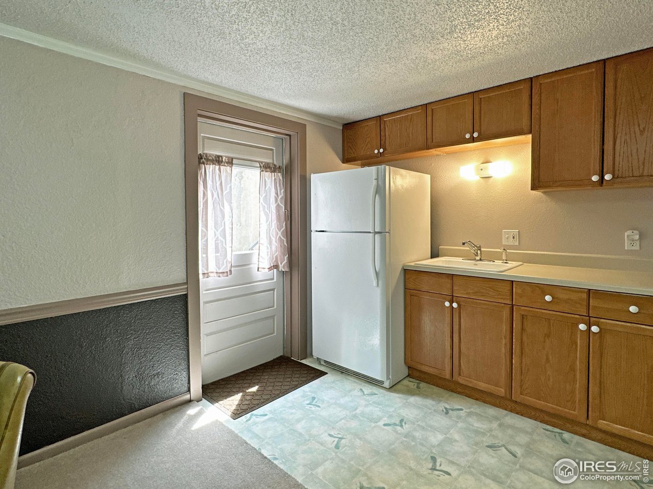 807 Locust Street Windsor, CO 80550 - Photo 25 of 40 a kitchen with a refrigerator and cabinets
