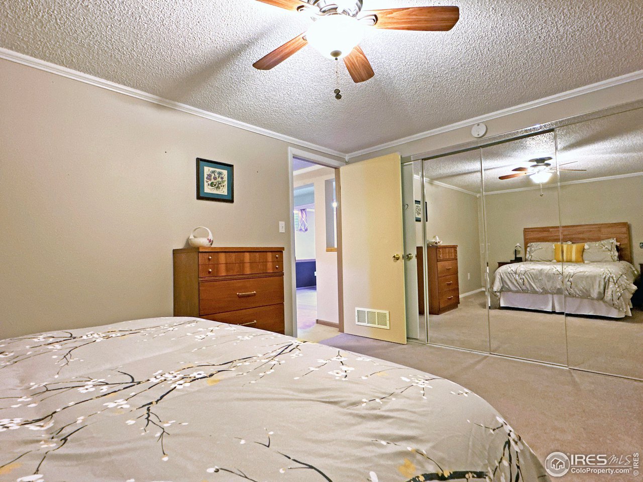 807 Locust Street Windsor, CO 80550 - Photo 27 of 40 a bedroom with a large bed and a chandelier