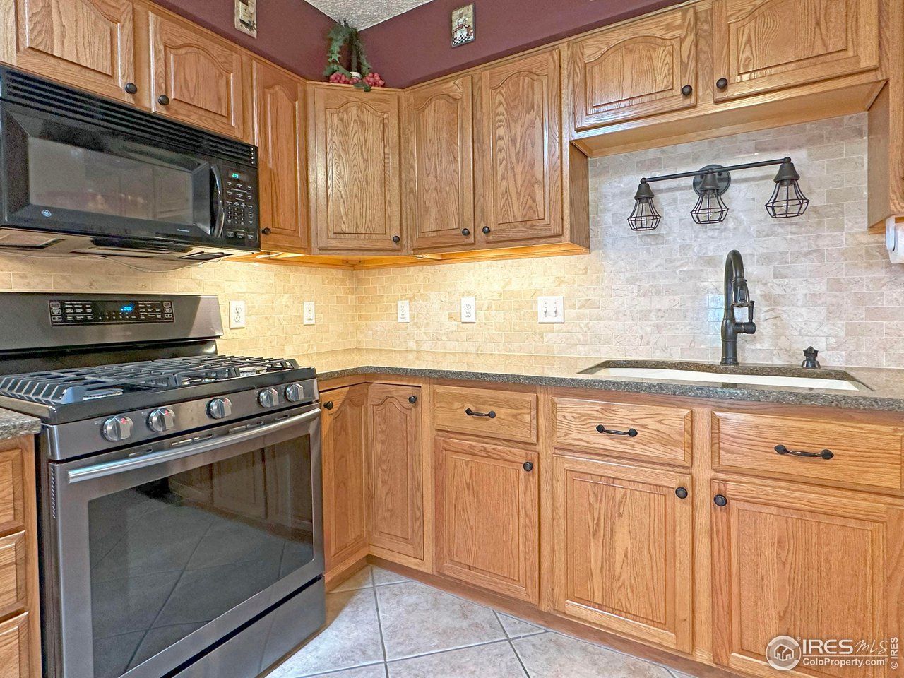 807 Locust Street Windsor, CO 80550 - Photo 8 of 40 a kitchen with granite countertop a stove microwave and sink