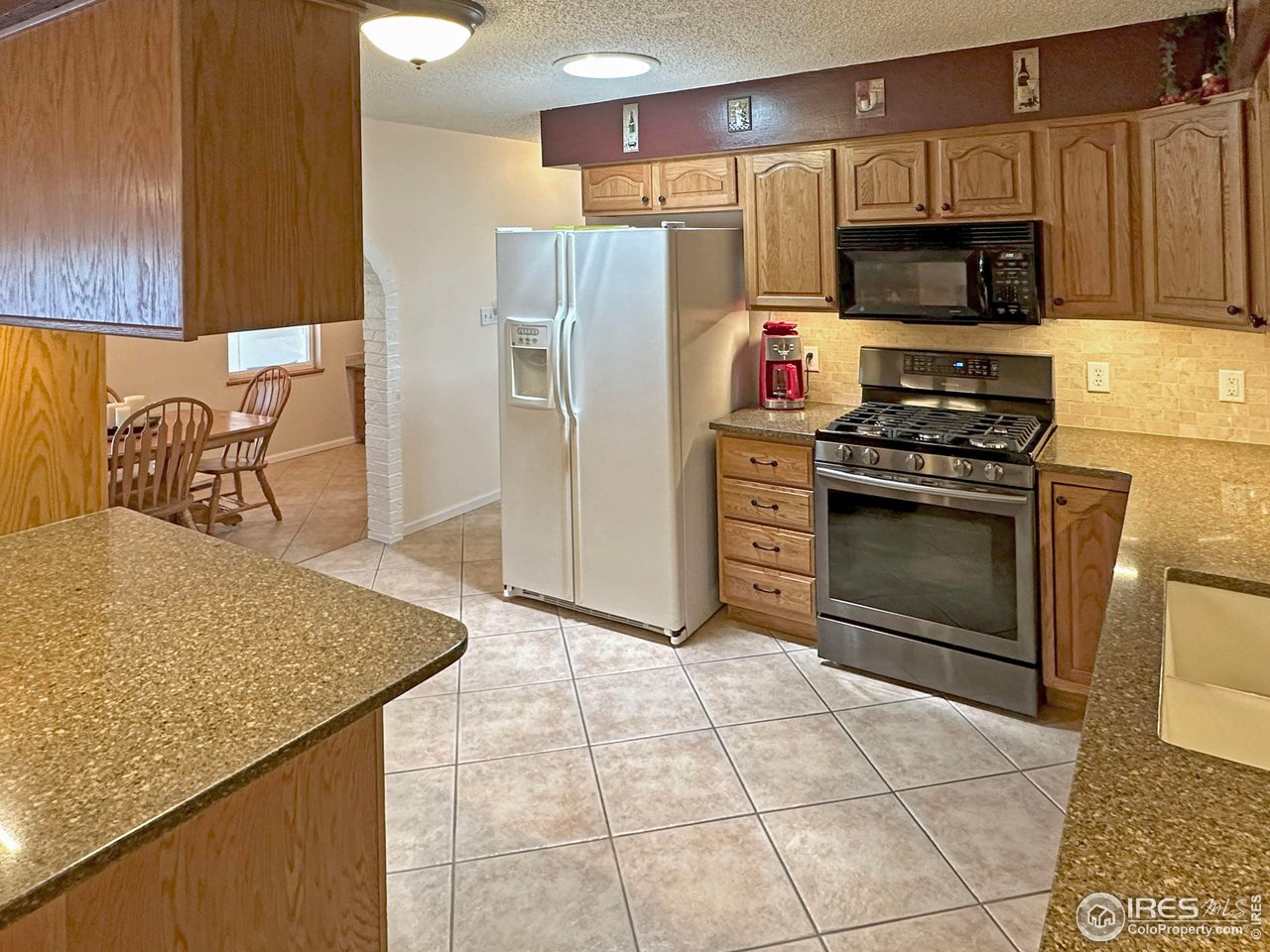 807 Locust Street Windsor, CO 80550 - Photo 9 of 40 a kitchen with stainless steel appliances granite countertop a stove a sink and a refrigerator