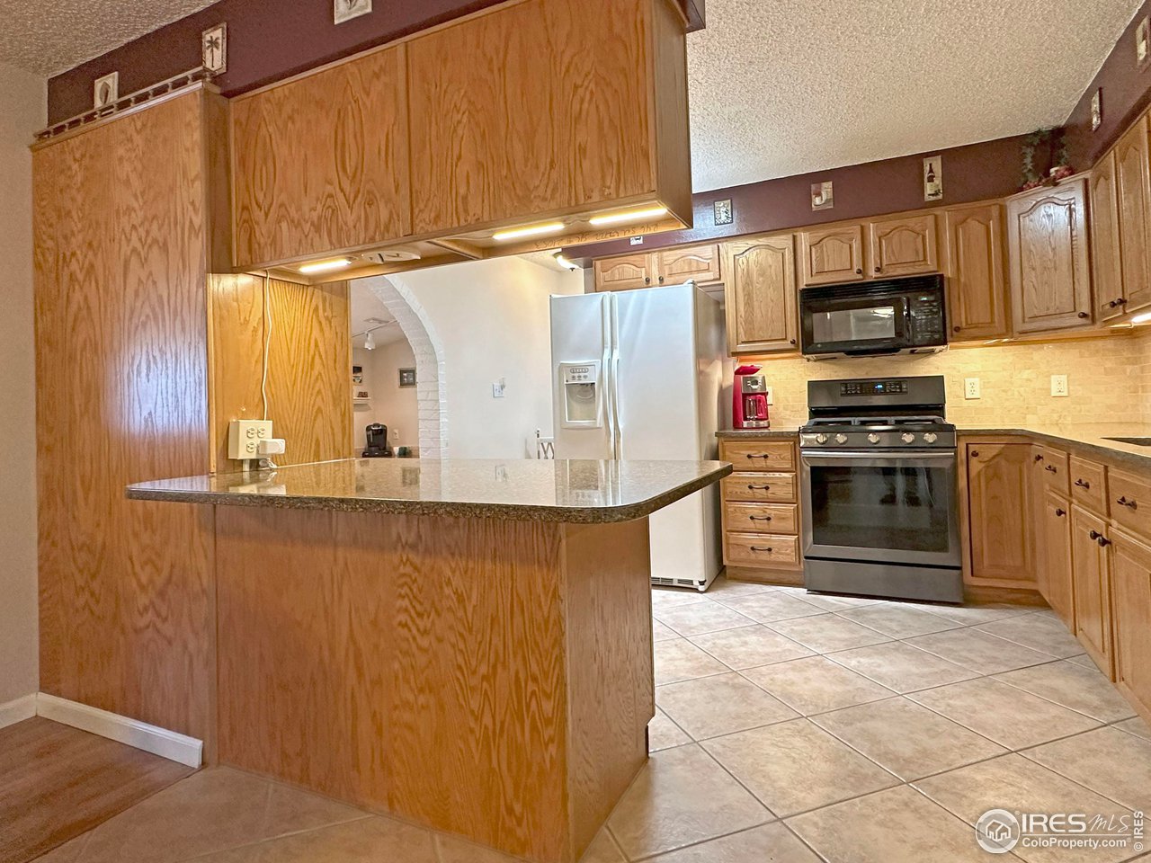 807 Locust Street Windsor, CO 80550 - Photo 10 of 40 a kitchen with stainless steel appliances a stove a microwave and a refrigerator