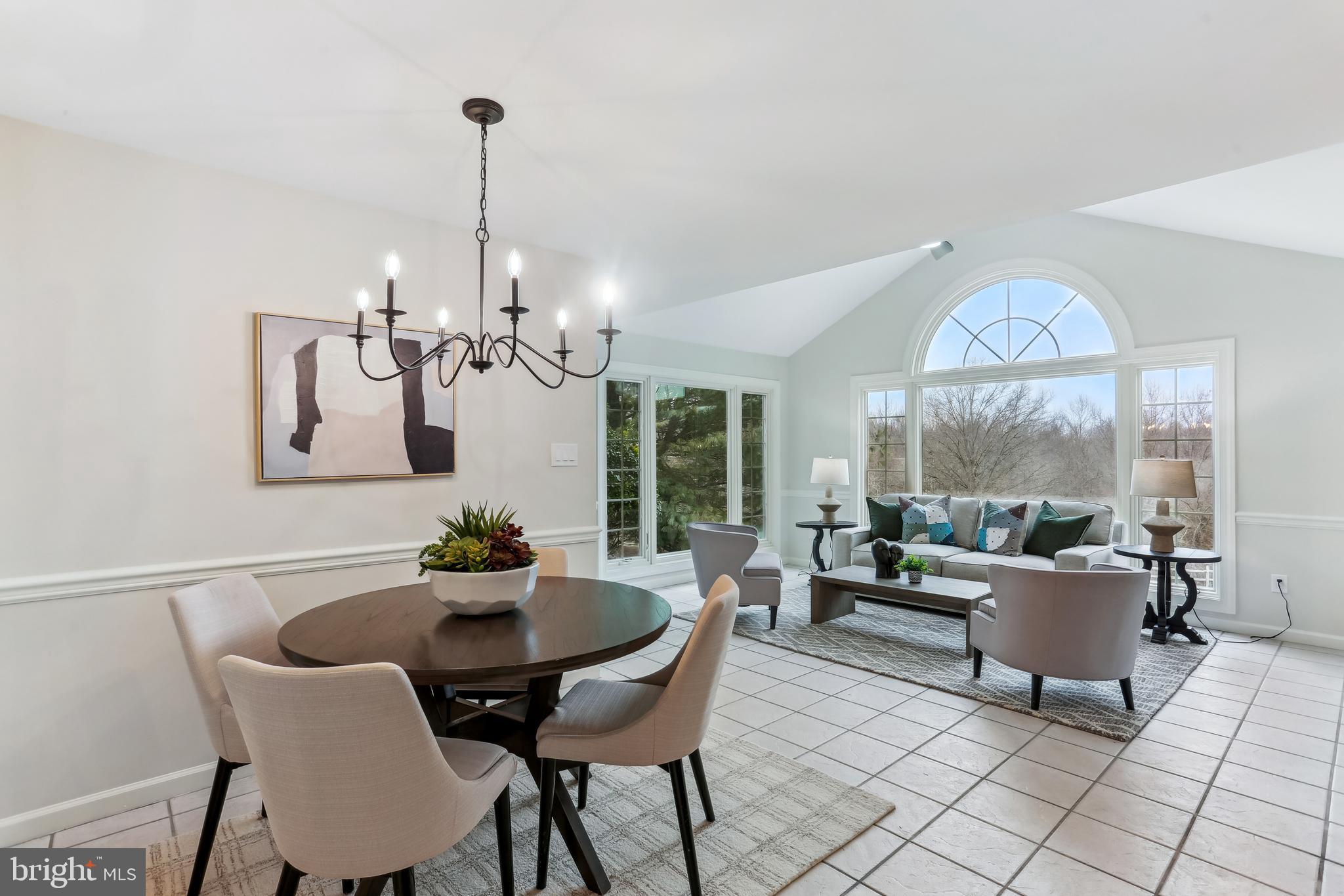 9409 Thornedike Drive Laytonsville, MD 20882 - Photo 3 of 86 a dining room with furniture a chandelier and a rug
