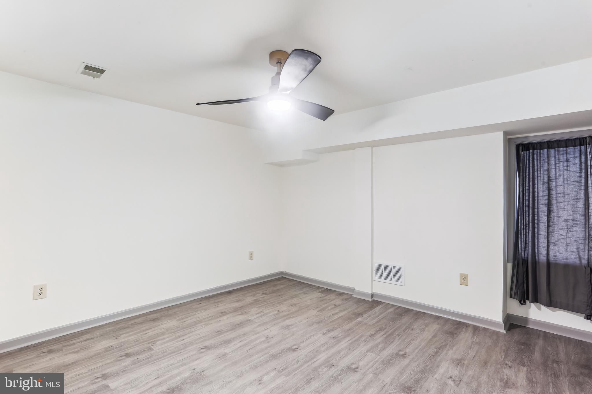 9409 Thornedike Drive Laytonsville, MD 20882 - Photo 71 of 86 a view of empty room with wooden floor and fan