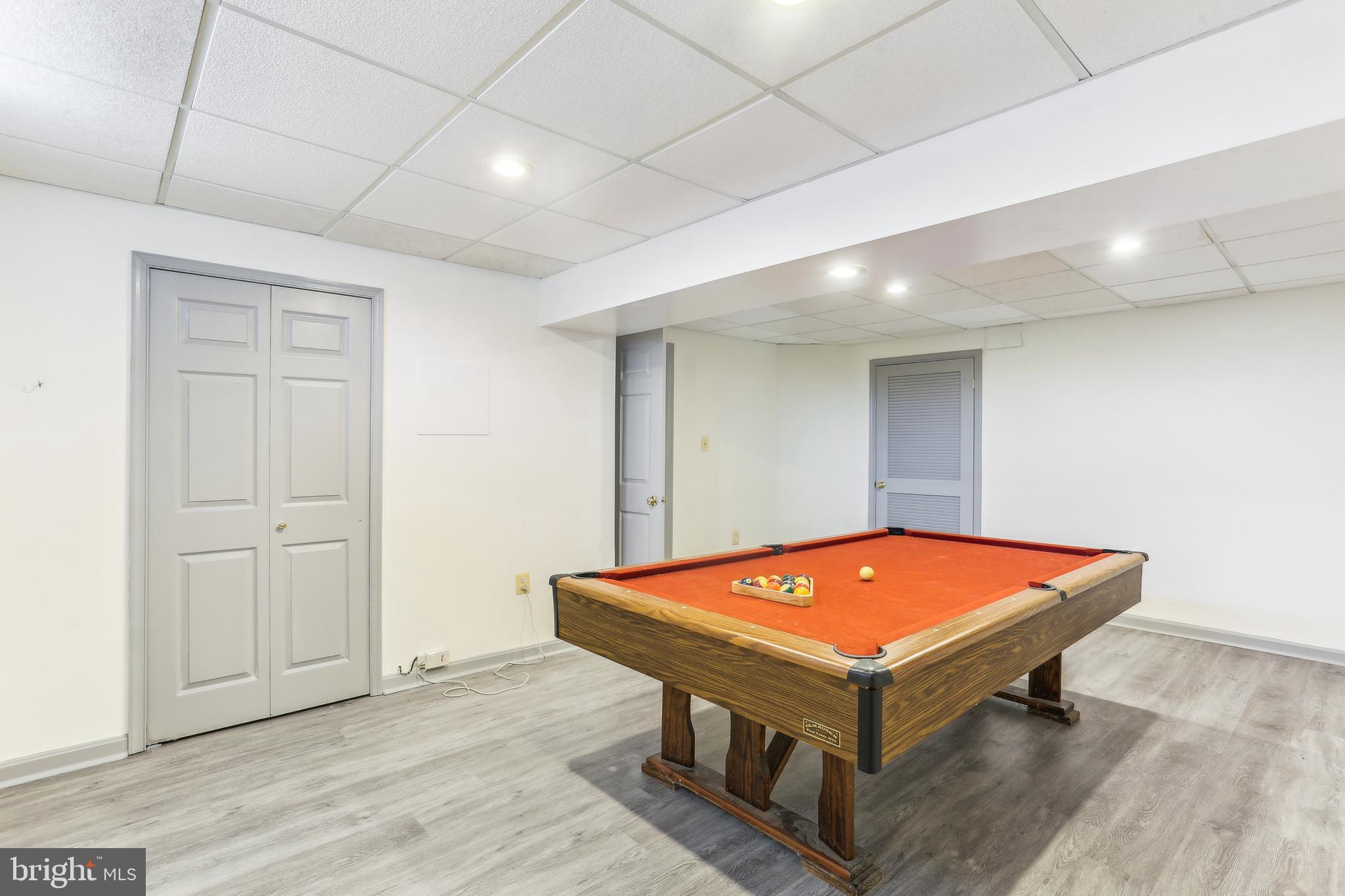 9409 Thornedike Drive Laytonsville, MD 20882 - Photo 75 of 86 a room with wooden floor pool table and windows