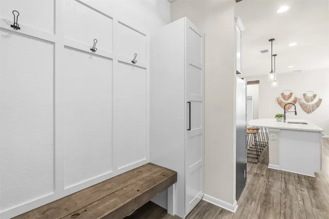a kitchen with stainless steel appliances sink stove and wooden floor