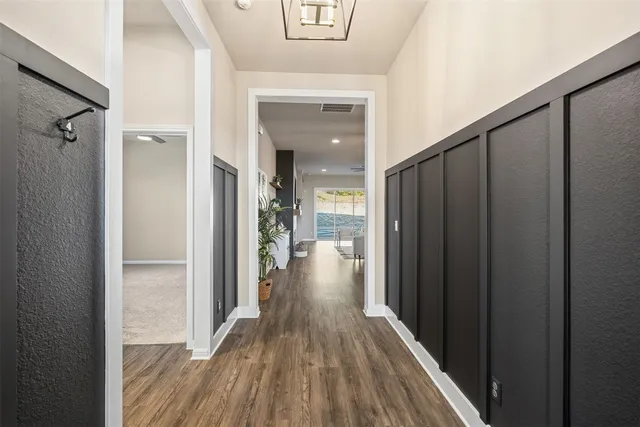 a view of a hallway with wooden floor and staircase