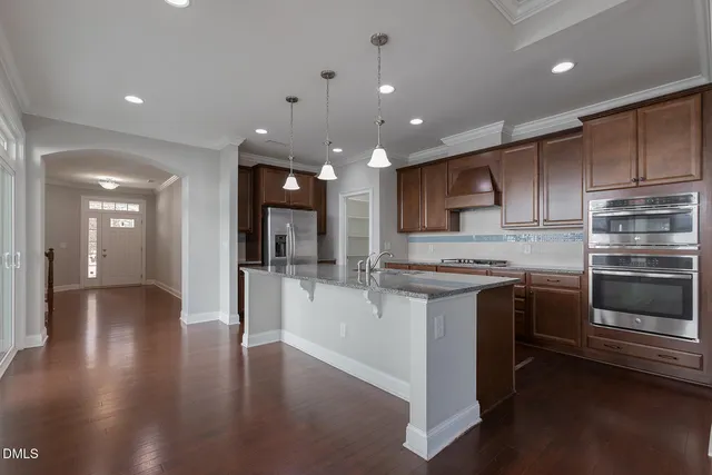 a kitchen with stainless steel appliances granite countertop a stove and a refrigerator