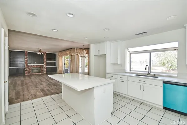 a large white kitchen with a stove a sink dishwasher and a refrigerator
