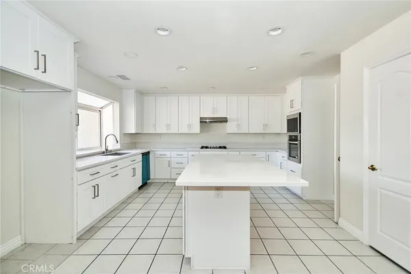 a large white kitchen with cabinets