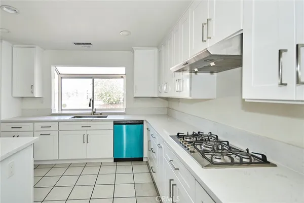 a kitchen with white cabinets and appliances