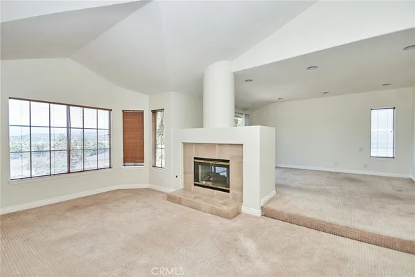 a view of an empty room with a fireplace and a window