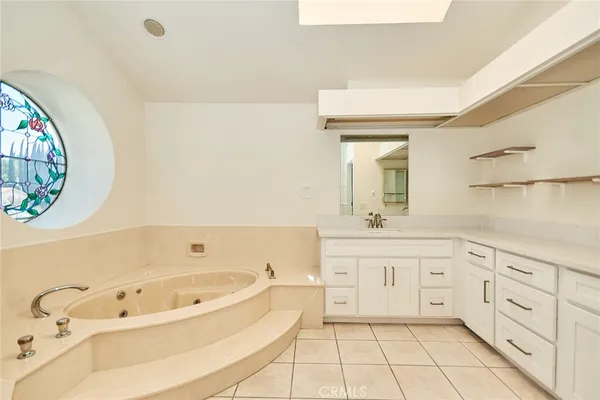 a spacious bathroom with a tub sink and mirror