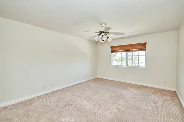 an empty room with a chandelier fan