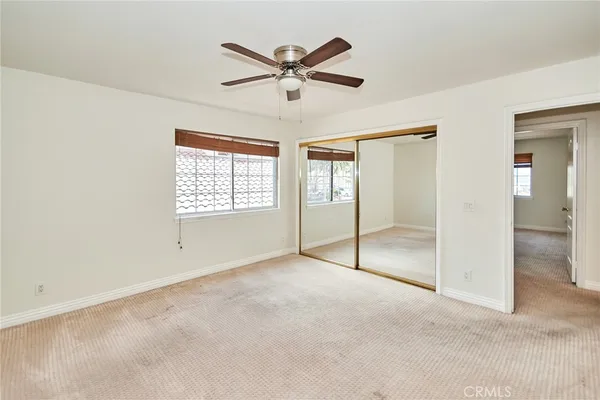an empty room with fan and windows