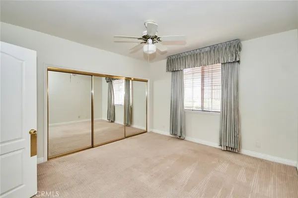 a view of a room with a ceiling fan and window
