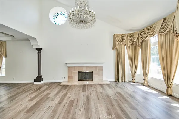 a view of an empty room with a fireplace and a window