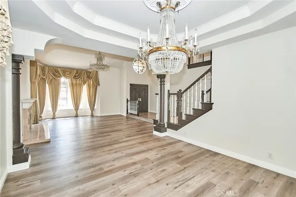 a view of a room with wooden floor chandelier and entryway
