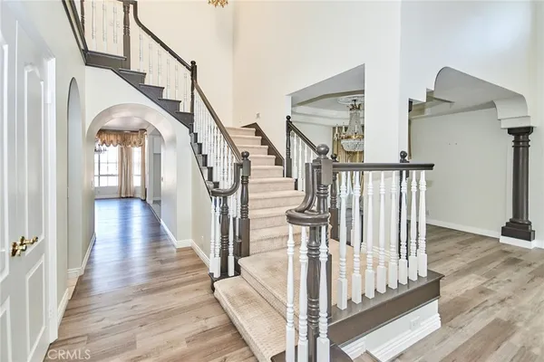 a view of staircase with lots of frames on wall and wooden floor