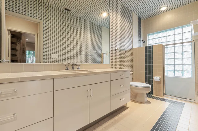 an aerial view of a houses with a garden and lake view