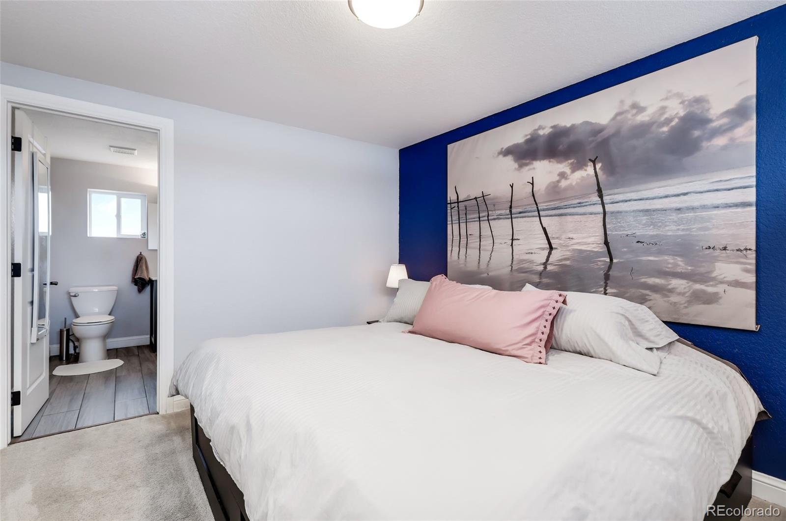 3051 Grape Street Denver, CO 80207 - Photo 19 of 33 a bedroom with a large bed and a painting on the wall