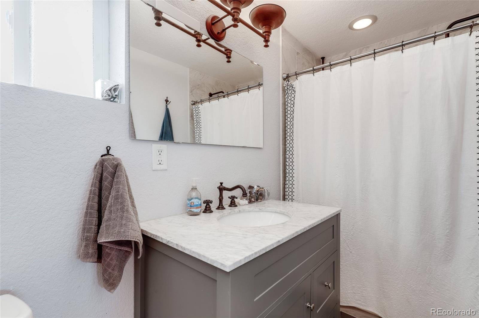 3051 Grape Street Denver, CO 80207 - Photo 22 of 33 a bathroom with a sink and a mirror