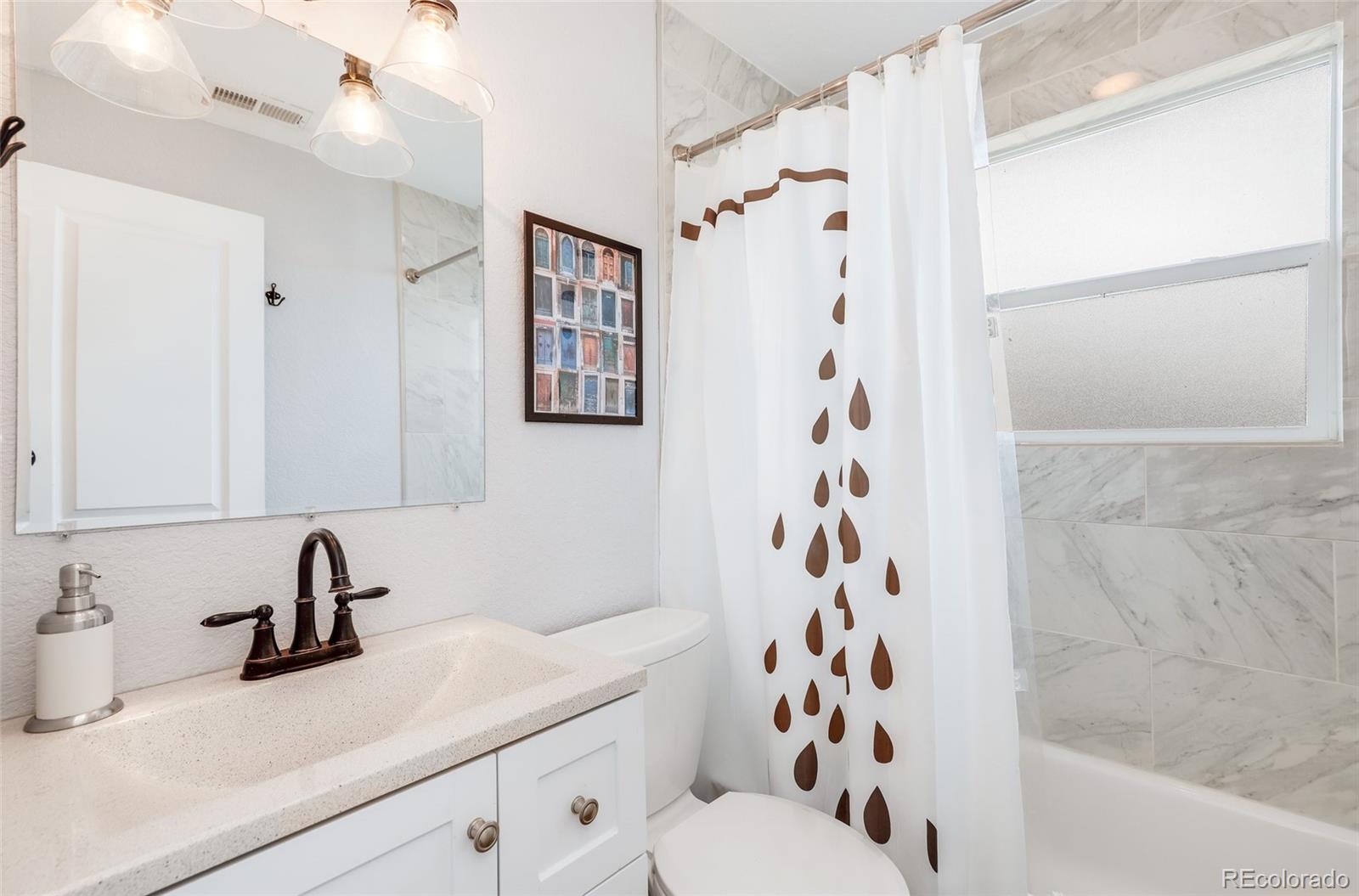 3051 Grape Street Denver, CO 80207 - Photo 23 of 33 a bathroom with a sink and a mirror