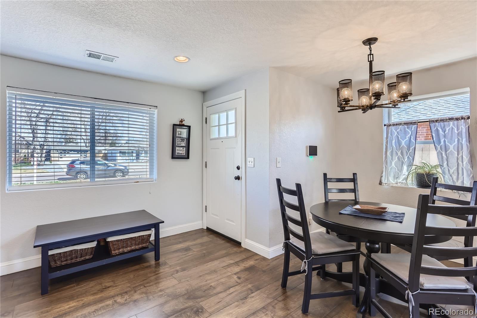 3051 Grape Street Denver, CO 80207 - Photo 3 of 33 a view of a dining room with furniture and wooden floor