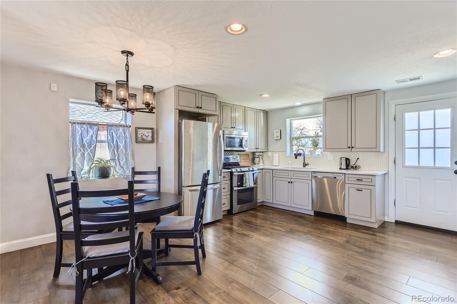 3051 Grape Street Denver, CO 80207 - Photo 4 of 33 a kitchen with sink a refrigerator and wooden floor