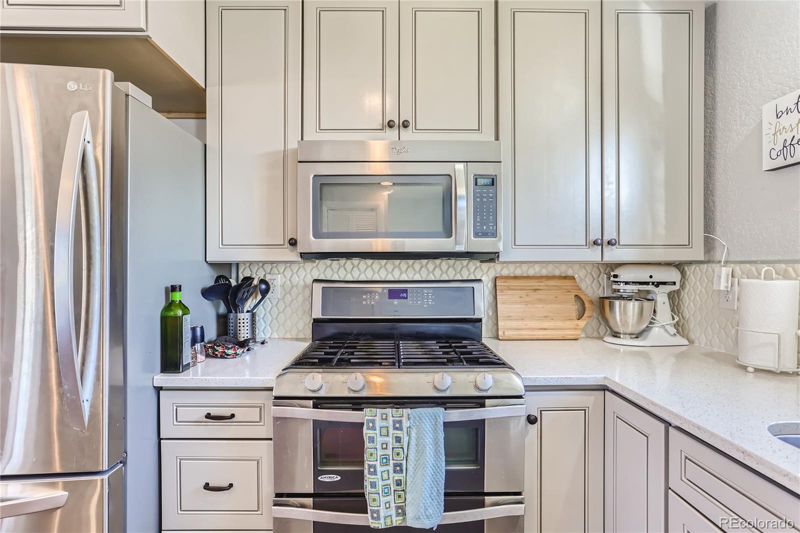 3051 Grape Street Denver, CO 80207 - Photo 5 of 33 a kitchen with granite countertop white cabinets and stainless steel appliances