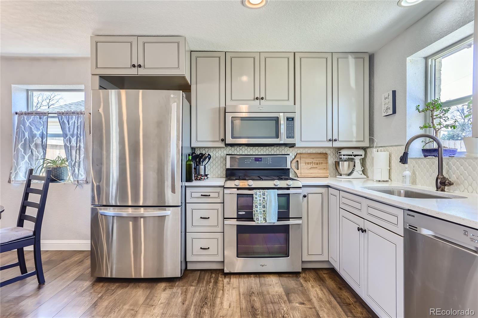 3051 Grape Street Denver, CO 80207 - Photo 7 of 33 a kitchen with wooden cabinets and stainless steel appliances