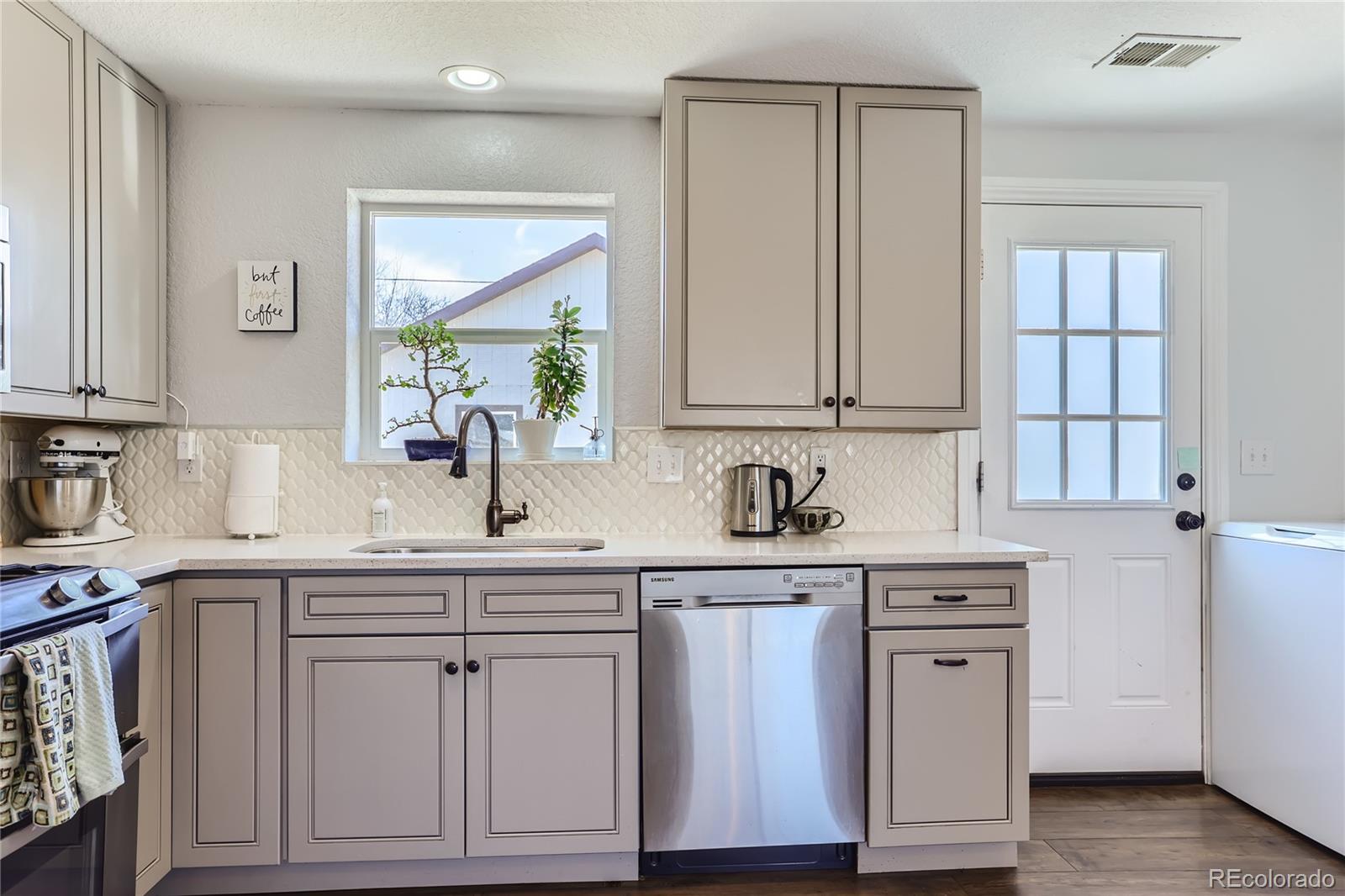 3051 Grape Street Denver, CO 80207 - Photo 10 of 33 a kitchen with white cabinets and sink