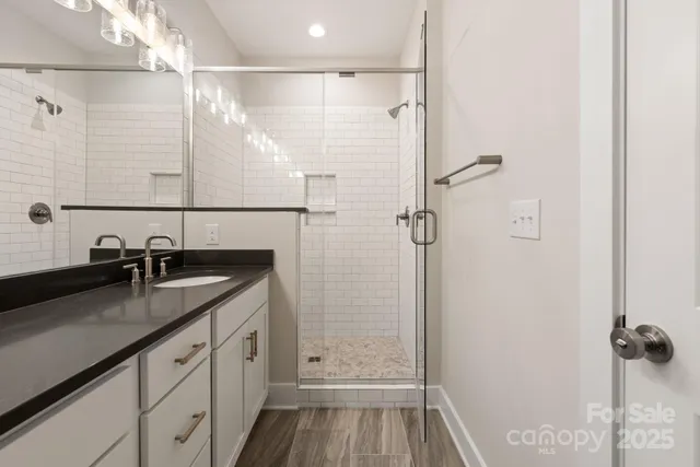 a bathroom with a granite countertop sink mirror and shower