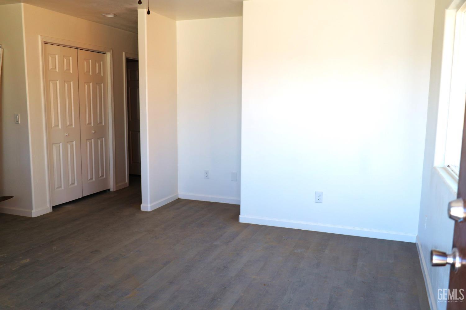 Undisclosed Address Bakersfield, CA 93307 - Photo 12 of 12 an empty room with wooden floor and windows