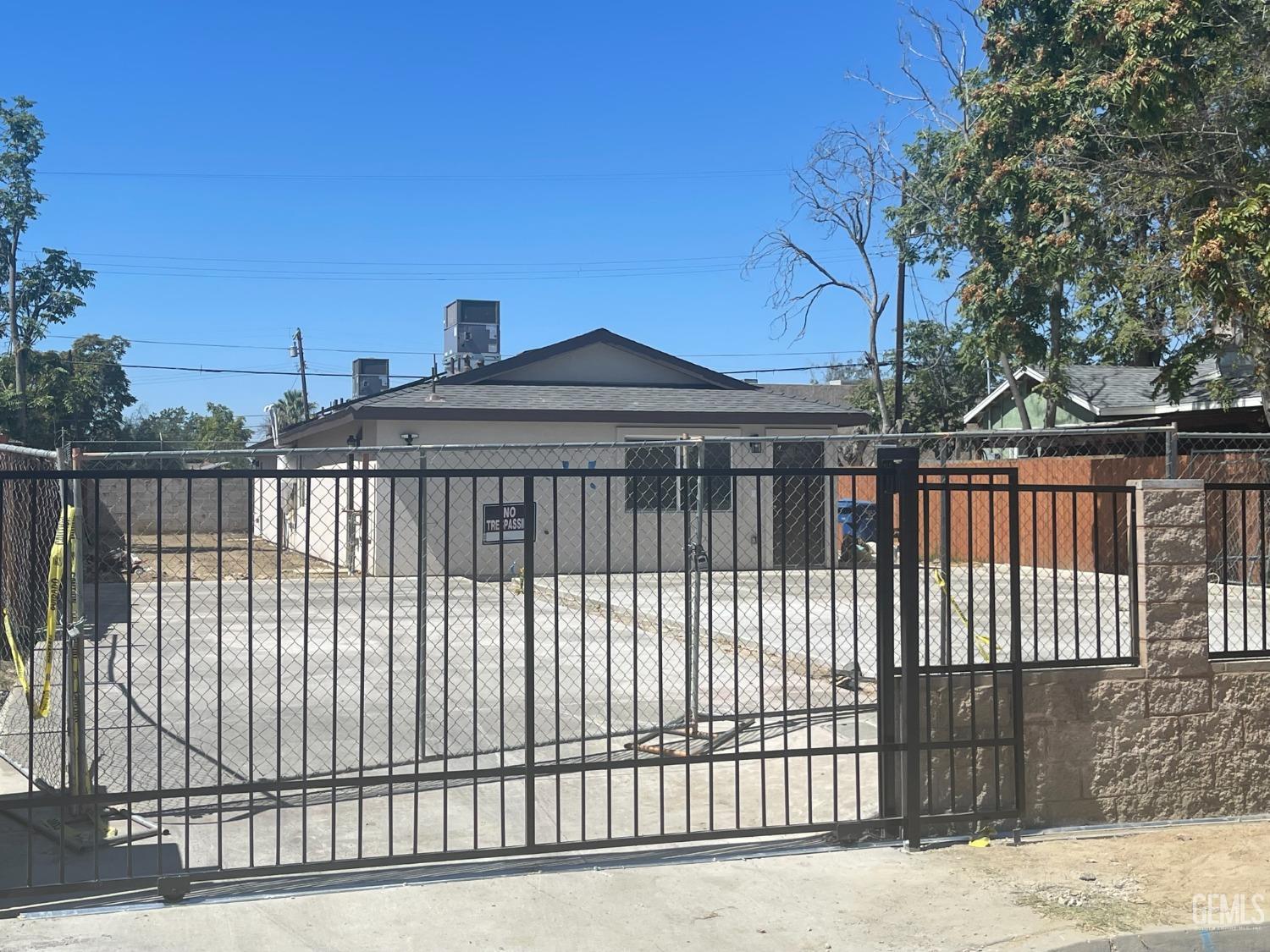 Undisclosed Address Bakersfield, CA 93307 - Photo 2 of 12 a front view of a house with a iron gate