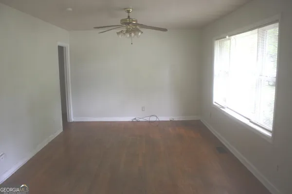an empty room with a window and a fan