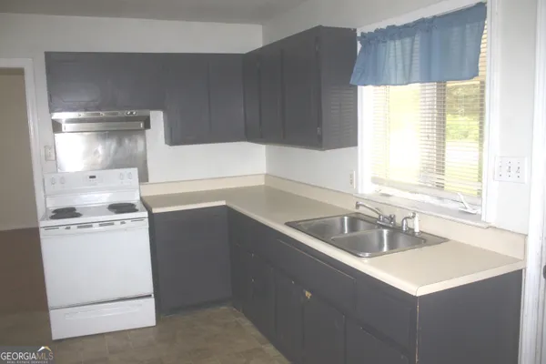 a kitchen with a sink stove and cabinets
