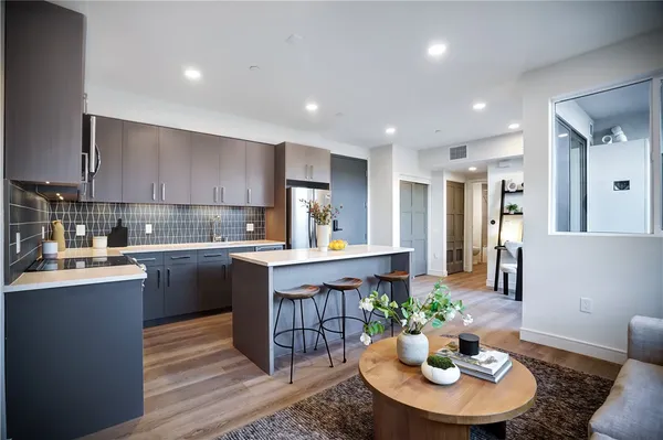 a kitchen with stainless steel appliances granite countertop a sink and a refrigerator