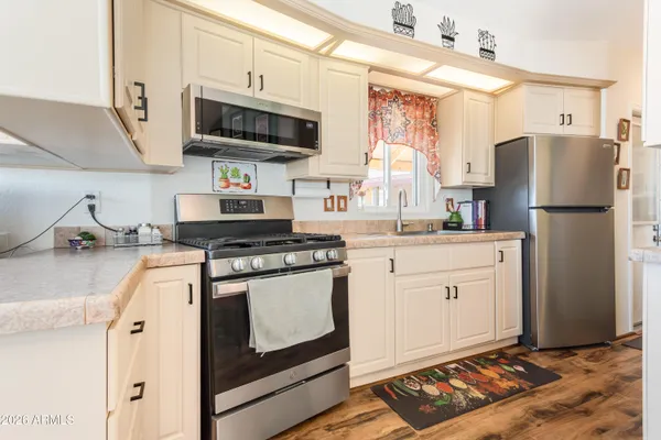 a kitchen with white cabinets and white appliances