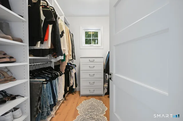 a view of walk in closet with clothes and shoes