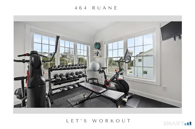 a living room with furniture gym equipment and a large window