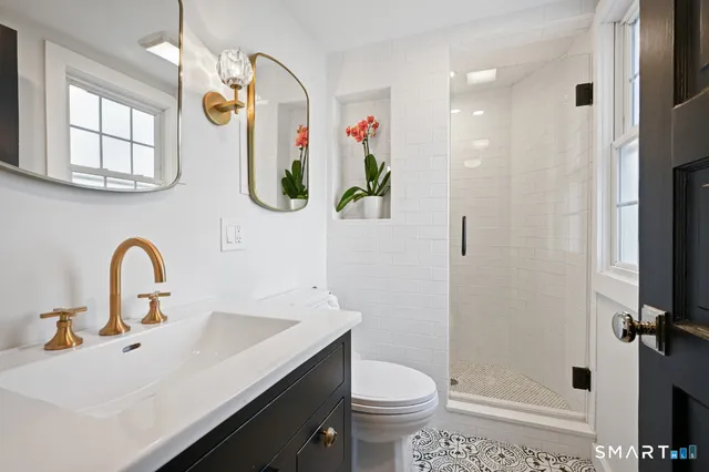 a bathroom with a sink a toilet and shower