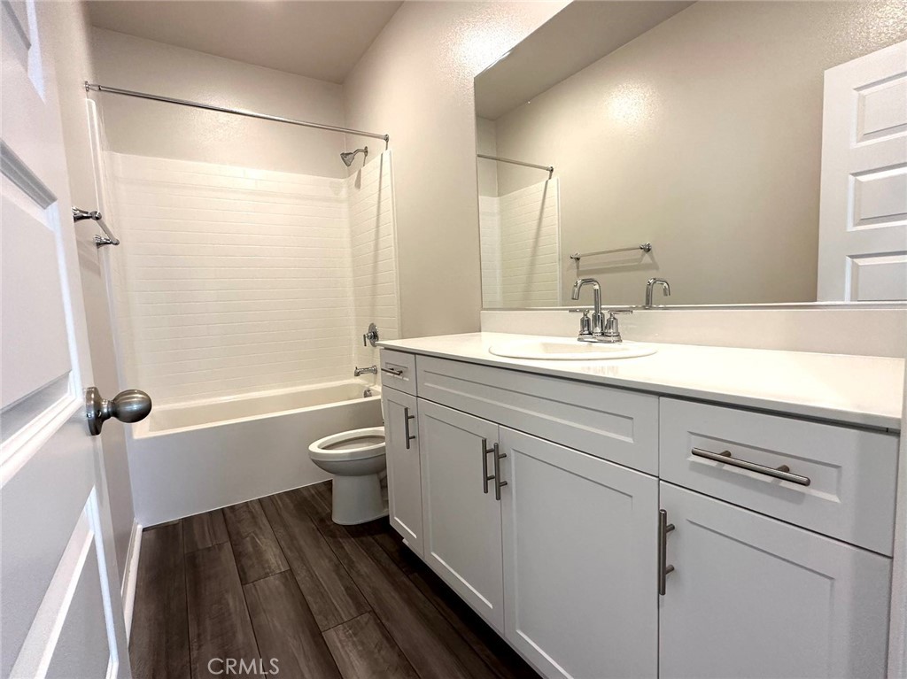 28221 Ashtree Street Temecula, CA 92591 - Photo 19 of 21 a bathroom with a granite countertop sink toilet a large mirror a shower and a bathtub
