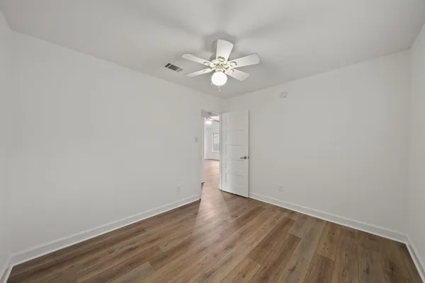 a view of an empty room with wooden floor