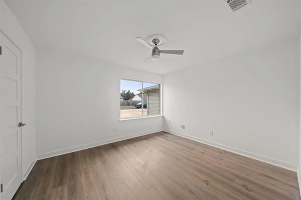 a view of a room with wooden floor and fan