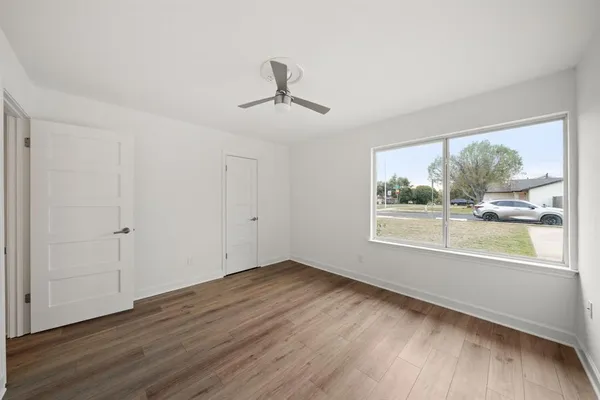 an empty room with wooden floor and windows