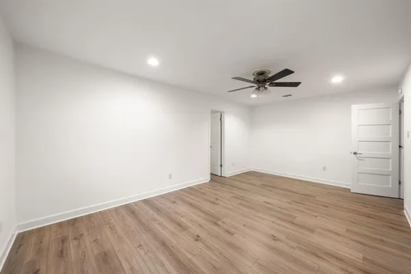 a view of a room with wooden floor and a ceiling fan