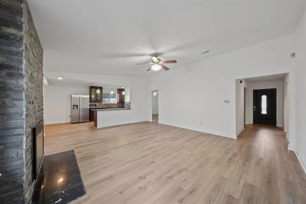 a view of a livingroom with wooden floor and a ceiling fan